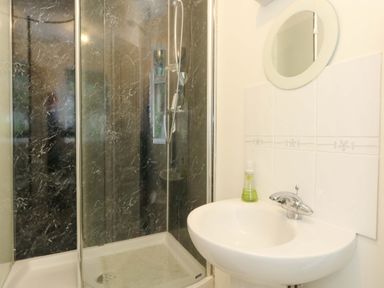 A bathroom with a shower and sink at 1 Fernhill Avenue Weymouth
