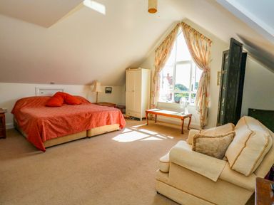 A bedroom with a bed and sofa at 1 Fernhill Avenue, Weymouth