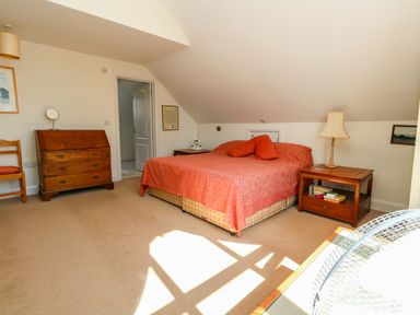 A bedroom with a bed, dresser and chair at 1 Fernhill Avenue Weymouth