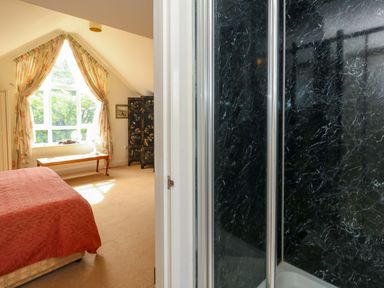 A bedroom with a bed and a shower visible at 1 Fernhill Avenue Weymouth