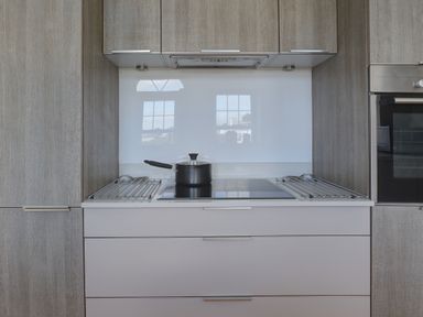 A kitchen stove with a pot on it surrounded by cabinets at The Tower 5 Corisande Manor in Newquay