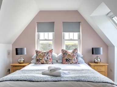 A bedroom with a bed and bedside tables with lamps at The Tower 5 Corisande Manor in Newquay