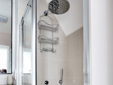 A shower area with a rain shower head and metal shelves in a bathroom at The Tower 5 Corisande Manor in Newquay