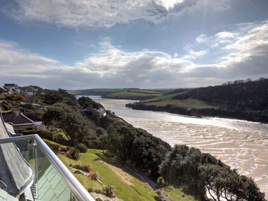 A river with surrounding green hills and trees viewed from a balcony at The Tower 5 Corisande Manor in Newquay