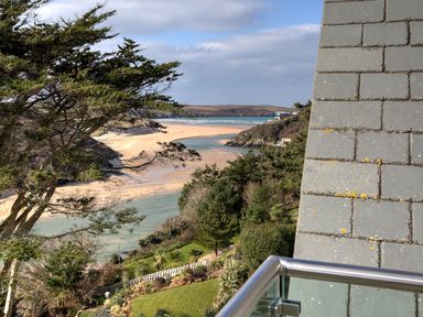 A coastal landscape with trees sandy beach and water view from a balcony at The Tower 5 Corisande Manor in Newquay