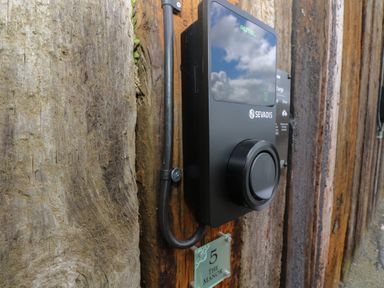 A black Autel Sevadis device mounted on a wooden wall next to a plaque reading 5 The Manor at The Tower 5 Corisande Manor in Newquay