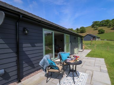 A patio with two chairs and a small table with wine glasses and food at Ystrad Wen in Llysdinam near Newbridge-On-Wye