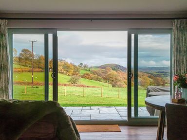 A view of rolling hills and trees from a room at Ystrad Wen in Llysdinam near Newbridge-On-Wye