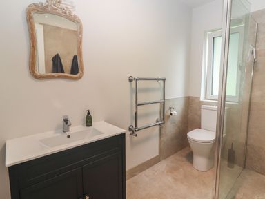 A bathroom with a sink cabinet a mirror a towel rack a toilet and a glass shower enclosure at Shannon Vale in Woodford County Galway