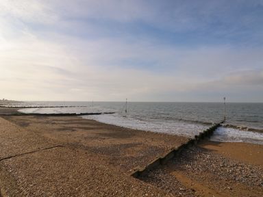 A beach with wooden groynes extending into the sea at Harveys Holiday House in Hunstanton