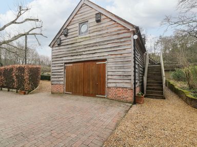 An exterior view of a wooden building with double doors and an outdoor staircase at Avon Turn View in Alderbury