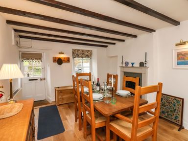 A dining room with wooden table and chairs set with plates and glasses at Riseholme in Ebberston