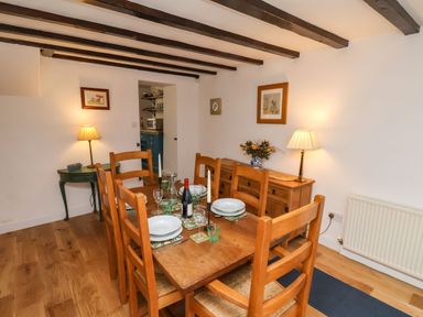 A dining room with wooden table and chairs set with plates glasses and a bottle of wine Riseholme Ebberston