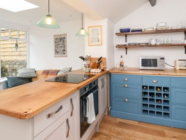 A kitchen with wooden countertops blue and white cabinets and open shelves at Riseholme in Ebberston