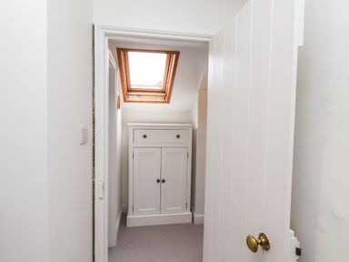 A small room with a skylight window and a white cabinet viewed through an open white door at Riseholme in Ebberston