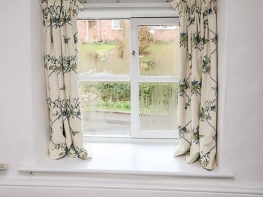 A window with floral patterned curtains and moisture on the glass at Riseholme in Ebberston