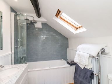 A bathroom with a bathtub shower combination and skylight window at Riseholme in Ebberston