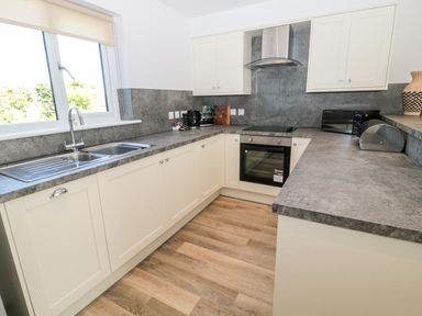 A kitchen with a double sink oven stovetop microwave and countertop appliances at Thrift Lodge in High Newton-by-the-Sea near Embleton