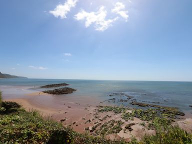 A coastal view with a beach seaweed rocks and jetty at Cornerside in Sidmouth