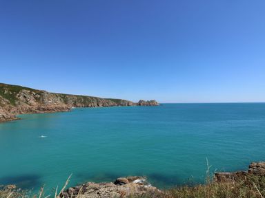 A coastal view with rocky cliffs and blue sea at Sun Rise in St Buryan