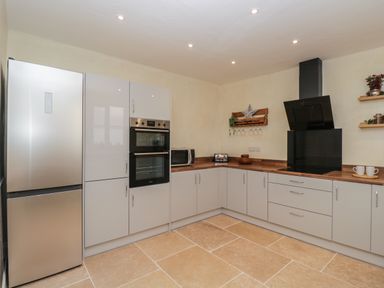 A kitchen with a refrigerator oven microwave stovetop and cabinets at The Hame in Monmouth