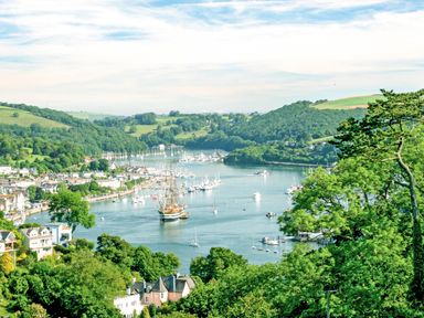 A river with boats and houses along the banks surrounded by green hills and trees at Magnolia House in Dittisham