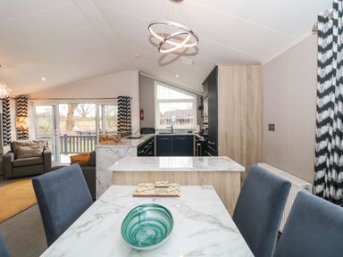 A kitchen and dining area with marble countertops and blue chairs at Owls Nest in Furzehill