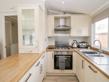 A kitchen with wooden countertops a stove oven kettle toaster and sink at Lake View Lodge in Lakeside 3 White Cross Bay Windermere