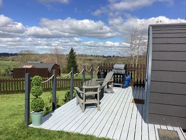 An outdoor area with a deck, chairs, and barbecue at Cherry Pod 2 Hookagate near Meole Brace