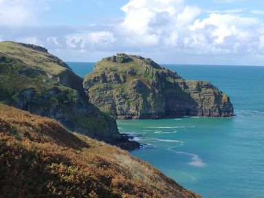 A coastal cliff with rocky formations and turquoise sea water at The Mill in Trethevy near Tintagel