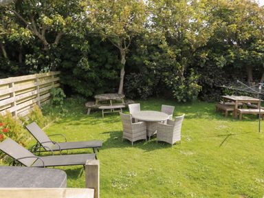 A garden with seating areas and a washing line at Porth Ewyn in Trearddur Bay