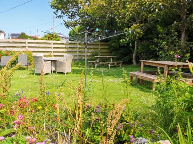 A garden with a table and chairs at Porth Ewyn in Trearddur Bay