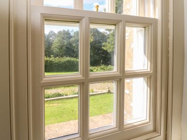 A window with six glass panes looking out to a garden and trees at The Pavillion in Kirklinton near Longtown