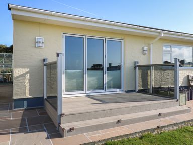 A patio with glass railing and double glass doors at Greenside Studio in Praa Sands