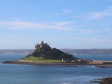 An island with a castle a few buildings and trees surrounded by water at Greenside Studio in Praa Sands