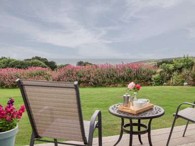 A garden with a table and chairs at Greenside Studio in Praa Sands