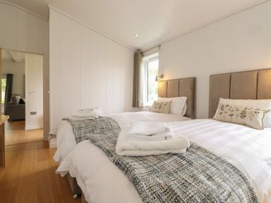 A bedroom with two beds and folded towels on them at The Brambles in Haverthwaite