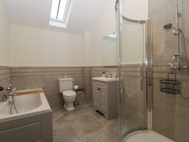 A bathroom with a bathtub toilet sink and a corner shower at The Byre in St Brides Major