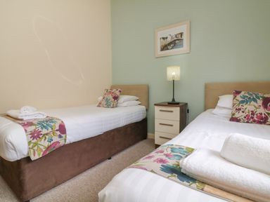A bedroom with two single beds bedside table and a lamp at Chalet Log Cabin L2 Combe Martin