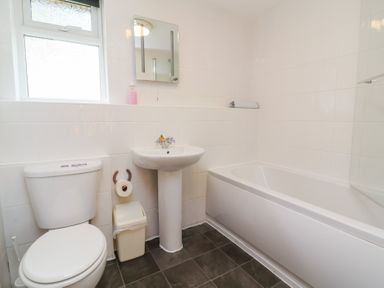 A bathroom with a toilet sink mirror and bathtub at Chalet Log Cabin C8 in Combe Martin