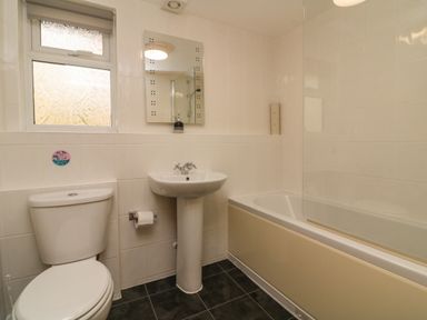 A bathroom with a toilet sink bathtub and a window at Chalet Log Cabin C9 in Combe Martin