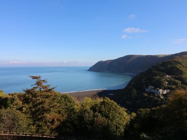 A coastal view with hills trees and buildings by the sea at Chalet Log Cabin C9 in Combe Martin