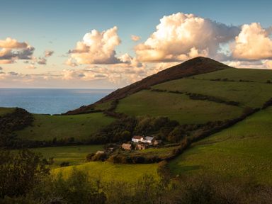 A landscape with hills and a farmhouse at 9 Manleigh Park in Combe Martin