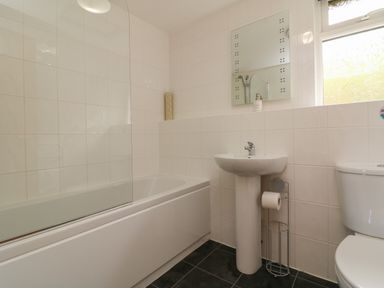 A bathroom with a bathtub shower sink and toilet at Chalet Log Cabin L14 in Combe Martin