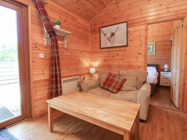 A wooden room with a beige sofa and a wooden coffee table at Chalet Lodge Bunks L1 in Combe Martin