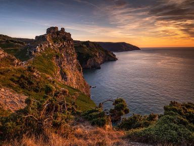 A cliff overlooking the ocean during sunset at 1 Manleigh Park Combe Martin