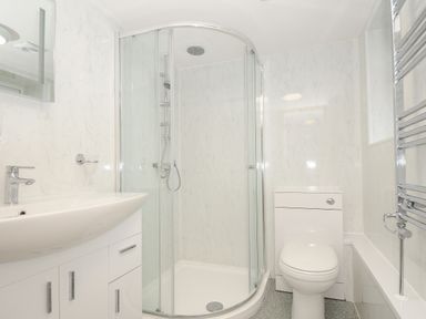 A bathroom with a shower enclosure sink toilet and heated towel rail at Bickle Bice Cottage in Minions near Liskeard