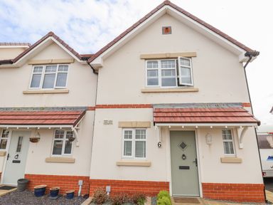 The exterior of a semi detached house with red brick and white walls at 6 Cwrt Griffiths in Prestatyn