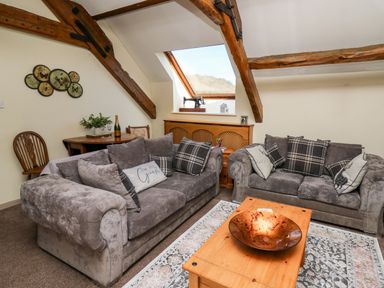 A living room with two sofas and a wooden coffee table under a skylight window at The Cheese Loft in White Mill near Carmarthen