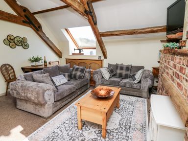A living room with two grey sofas and a wooden coffee table under a skylight at The Cheese Loft in White Mill near Carmarthen